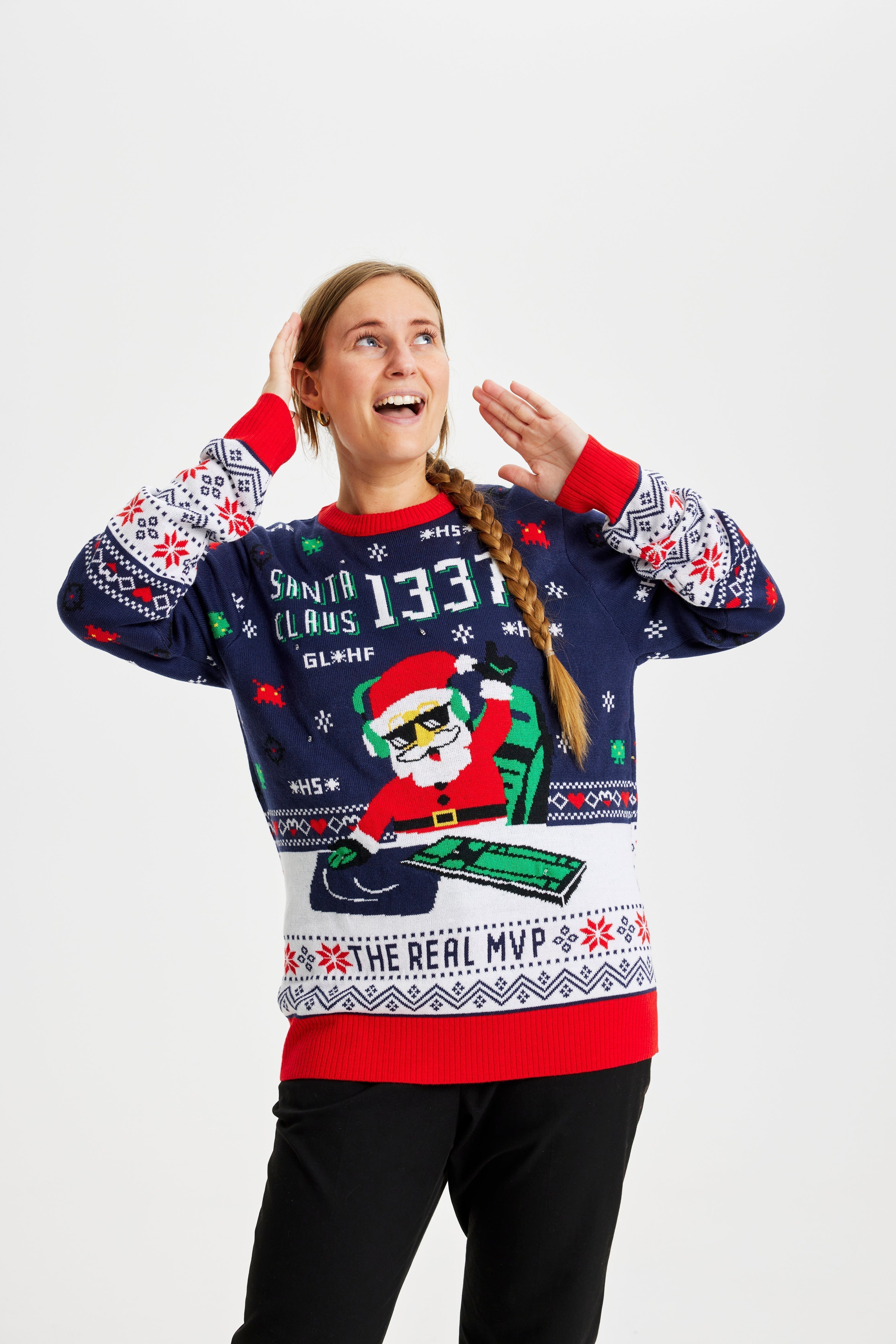 Une femme dansante portant un pull de Noël bleu et rouge avec un Père Noël et des lumières.